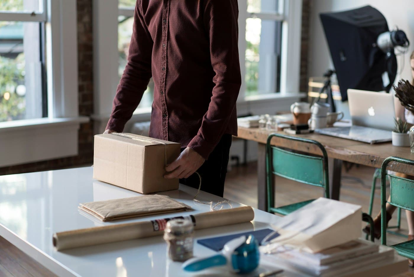 A person preparing a cardboard box for delivery